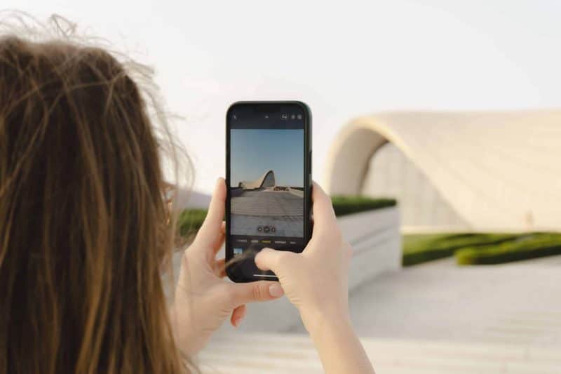 Persona fotografiando arquitectura con el móvil para crear contenido turístico