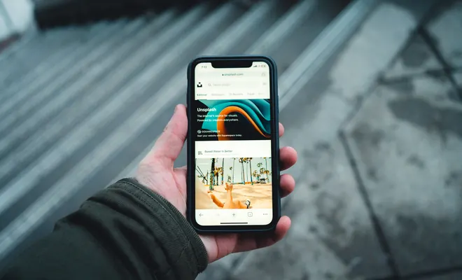 Manos usando un smartphone que muestra una web de imágenes en la calle