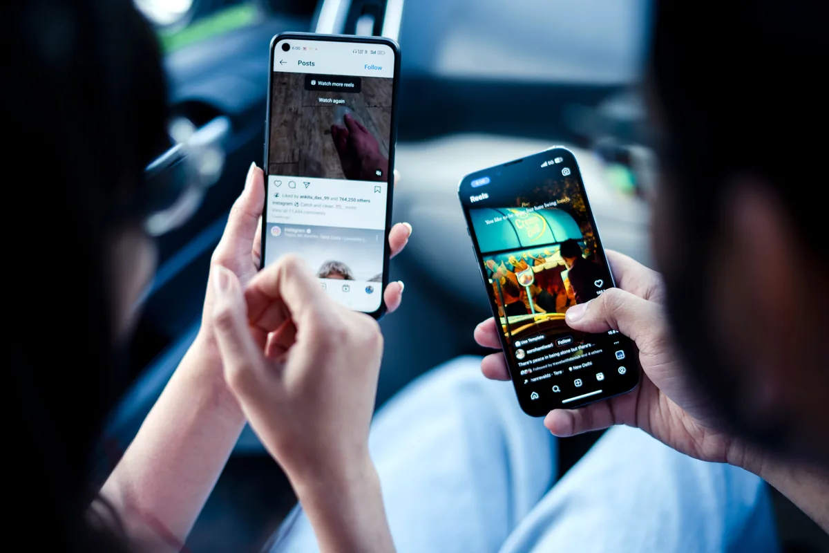 Dos personas viendo publicaciones y reels de Instagram en sus móviles