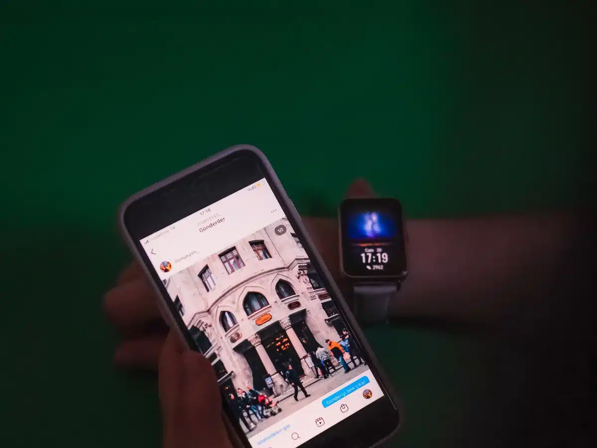 Persona viendo una publicación de Instagram en el móvil junto a un smartwatch