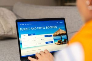 Portátil mostrando una web de reservas de vuelos y hoteles