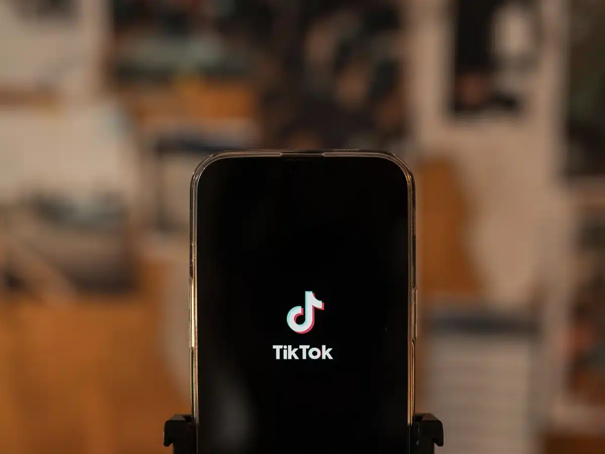 Móvil sujeto a un trípode mostrando la pantalla de inicio de TikTok