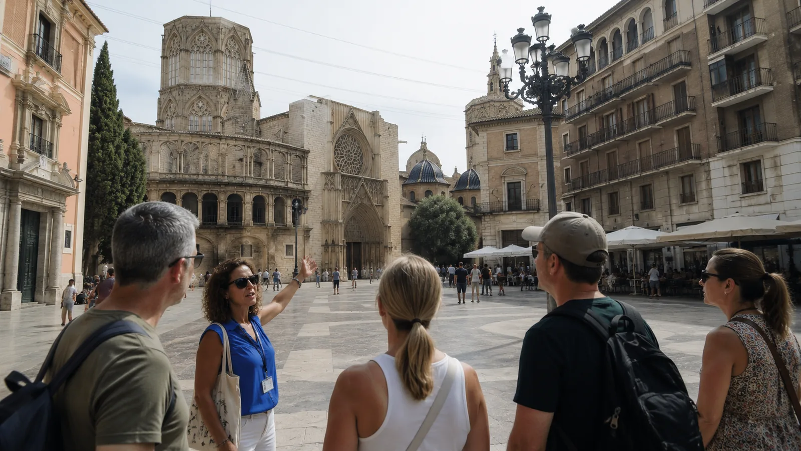 Guía explicando a un grupo de turistas en la plaza de la Virgen, frente a la catedral de Valencia
